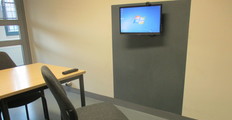 Raum in der JVA Sehnde. Ein Stuhl steht vor einem Bildschirm für die Videotelefonie.