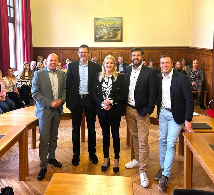 Oliver Ebken, Andreas Frank, Dr. Kathrin Wahlmann, Daniel Schneider und Manuel Haase. Im Hintergrund sind die Mitarbeiterinnen und Mitarbeiter des Amtsgerichts Cuxhaven zu sehen.