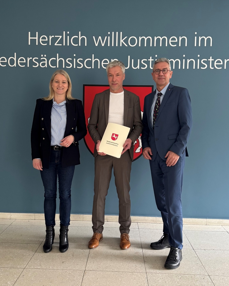Justizministerin Dr. Wahlmann und Staatssekretär Dr. Smollich mit Herrn Dr. Henjes, der seine Urkunde ausgehändigt bekommen hat.