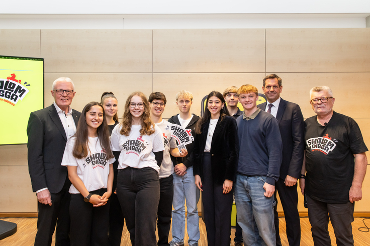 Eine Gruppe Menschen, darunter der Ministerpräsident Lies und Antisemitismusbeauftragter Prof. Dr. Wegner, die Werbung für die Kampagne "Shalom, Digga" machen